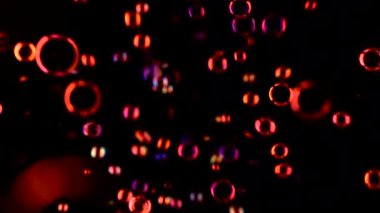 Küçük yuvarlak şeffaf sabun köpüğü çok hızlı uçar. Siyah arka plan