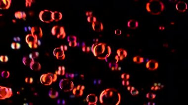 Kırmızı sabun balonları havaya uçar. Siyah arka plan