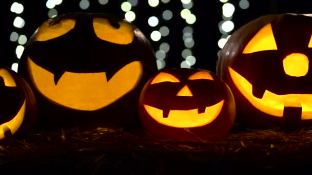 Halloween és ünnepek fogalom - kísérteties jack-o-lantern vagy faragott sütőtök. Közelről. Fekete bokhe háttér — Stock videók