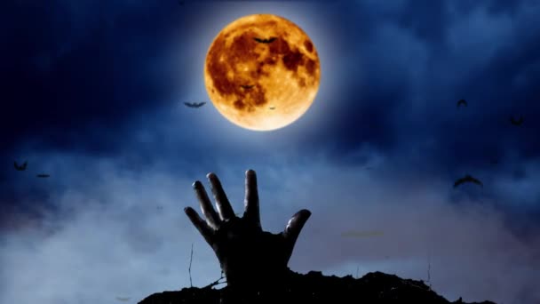 Hand of a zombie comes out of the ground from behind bats and yellow moon. Night sky background — Stock Video