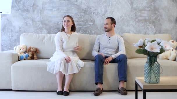Семья сидит на диване и разговаривает — стоковое видео