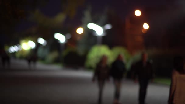 夜の路地を歩く人の抽象的な背景をぼかした写真 — ストック動画