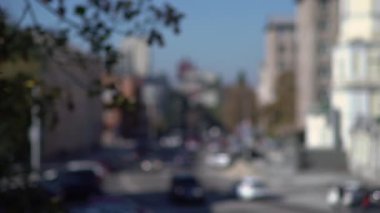 Güneş ışınlarının kasaba sokaklarında araba trafiği olan kentsel arka plan bulanık