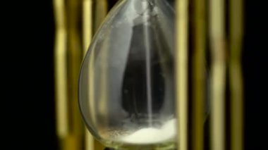 Kum saati onlar döndürmek siyah bir arka plan ile kum. Yakın çekim