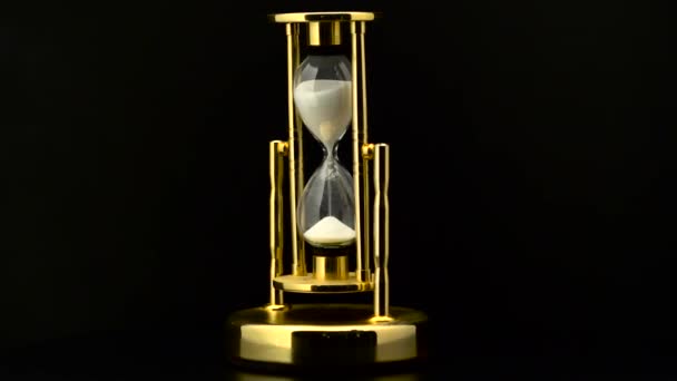 Вінтажний пісочний годинник з обертанням білого піску. Чорний фон — стокове відео