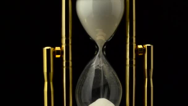Přesýpací hodiny je vyroben ze skla, dřevěné a písku. Černé pozadí — Stock video