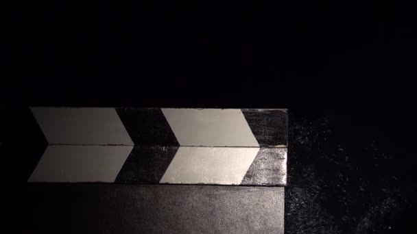 Ταινία σχιστόλιθο χτύπησε με ένα σύννεφο σκόνης κιμωλίας. Κοντινό πλάνο. Μαύρο φόντο — Αρχείο Βίντεο