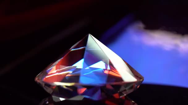 Diamante girando sobre una superficie y parpadeando en rayos de luz — Vídeos de Stock