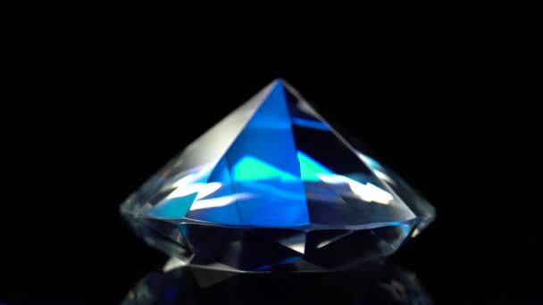 Diamante está girando e brilhando com cor azul escuro. Fundo preto — Vídeo de Stock