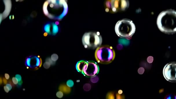 Medium soap bubbles spinning. Slow motion. Black background. — Stock Video