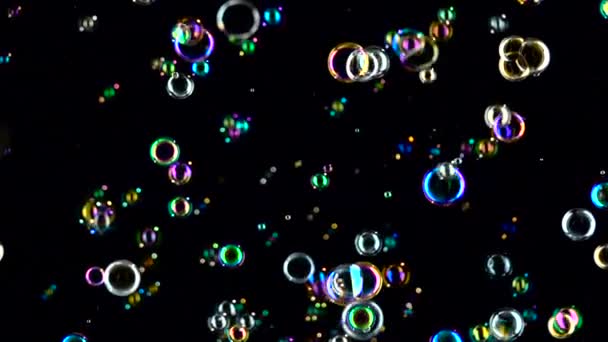 Las burbujas de jabón de colores vuelan. En cámara lenta. Fondo negro . — Vídeo de stock