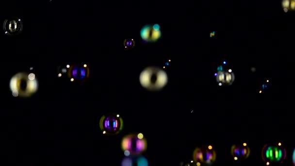 Floating soap bubbles in the air close up. Slow motion. Black backgroungs — Stock Video