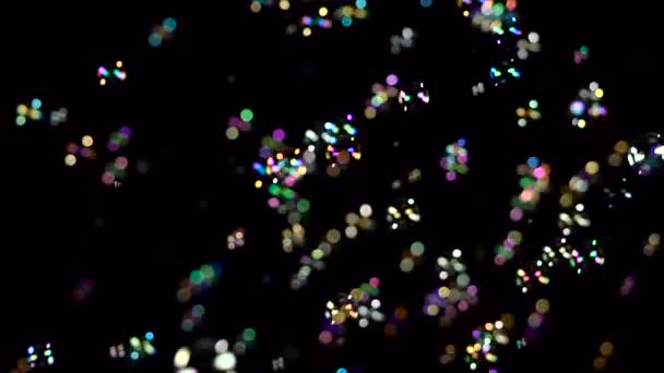 Zeepbellen vliegen en fade in verschillende kleuren. Slow-motion. Zwarte achtergrond — Stockvideo