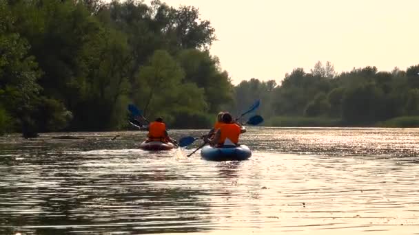 Aufnahme von Kajakfahrern, die in einer Landschaft den Fluss hinunter paddeln. Zeitlupe — Stockvideo