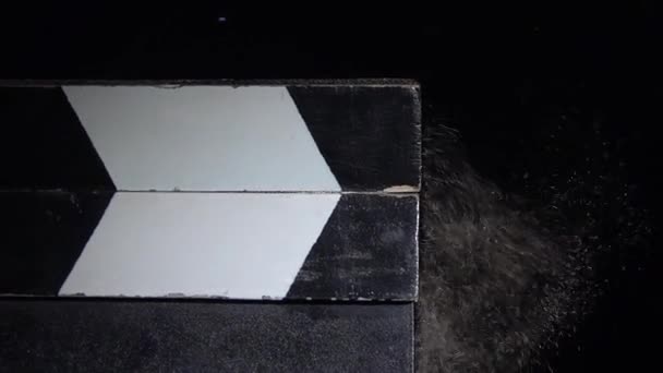 Klapptafel mit einer Wolke aus Kreidestaub. Nahaufnahme. schwarzer Hintergrund. Zeitlupe — Stockvideo