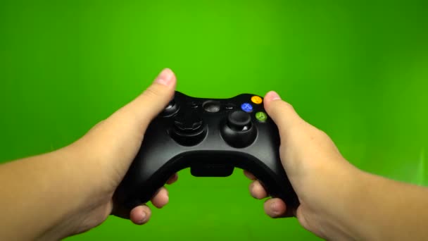 Руки игрока управляют клавишами джойстика, играющими на зеленом экране — стоковое видео