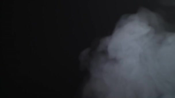 El vapor blanco se eleva sobre un fondo negro — Vídeo de stock