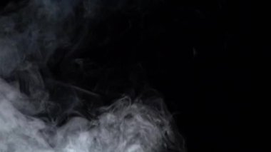 Beyaz buhar bir siyah arka plan üzerinde yükselir. Ağır çekim