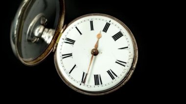 Vintage tasarım closeup kadranı ile okları siyah arka plan ile cep saati. Timelapse