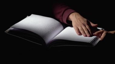 Karanlık bir odada körler için kitap okurken erkek. Yakın çekim