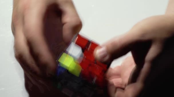 Homem coleta cubo Rubiks quebra-cabeça. Fechar — Vídeo de Stock