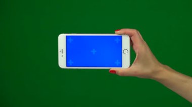 Bir mavi ekran smartphone üzerinde yeşil bir ekran tutan el