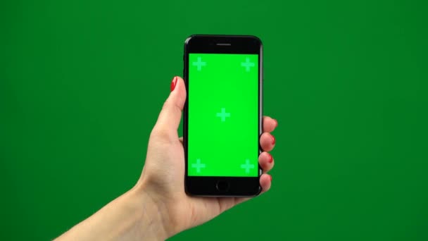 Mano femenina sosteniendo el teléfono inteligente más nuevo en la pantalla verde — Vídeos de Stock