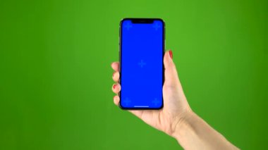 Holding bir hareket eden smartphone mavi ekran ver. Yeşil ekran