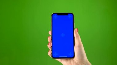 En yeni smartphone yeşil ekran üzerinde tutan el