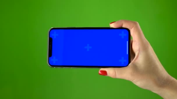 Смартфон в женской руке на зеленом экране — стоковое видео