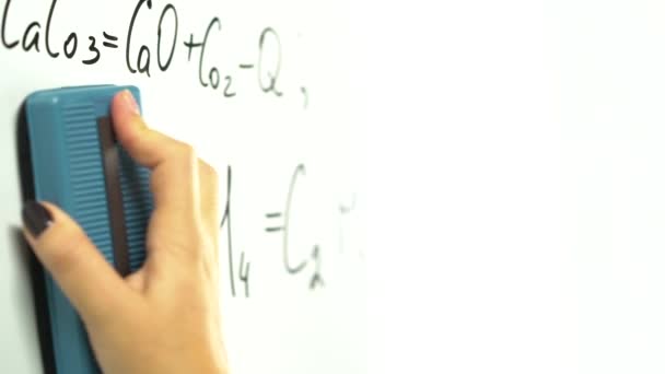 Fille efface les formules chimiques du tableau — Video