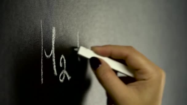 Chica escribiendo fórmula química en tablero negro — Vídeos de Stock