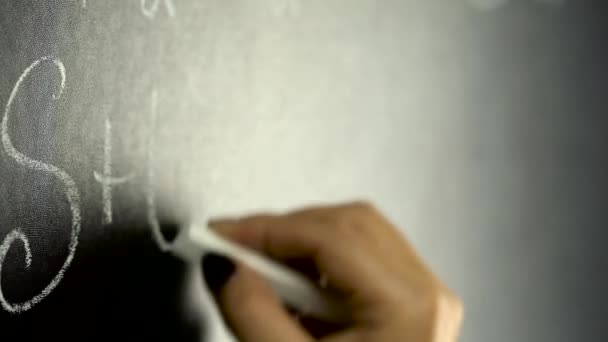 Woman writing chemistry formula on black board — Stock Video