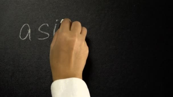 A mão está escrevendo com um giz uma matemática de uma fórmula em um quadro negro — Vídeo de Stock