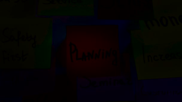 Karanlık odada bir gemide planlama bir yazıt ile bir turuncu etiket tutkallar — Stok video