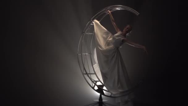Мистецька гімнастика дівчина в сукні обертається в розколі на будівельному місяці. Дим фон — стокове відео