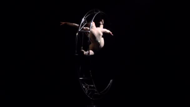 Acrobat ruota su una struttura metallica in una corda verticale. Fondo nero — Video Stock