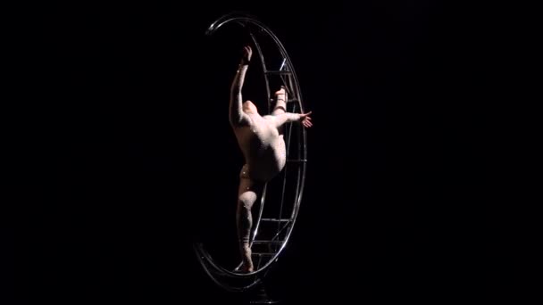 Akrobat dreht sich auf einer Metallstruktur in einer senkrechten Schnur. schwarzer Hintergrund — Stockvideo