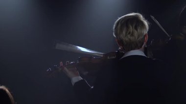 Geri duran ve keman bir gece odada oynayan kadın. Siyah duman arka plan