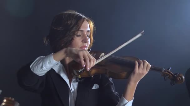 Meisjes in spelen de violen in een compositie in een kamer. Zwarte rook achtergrond — Stockvideo