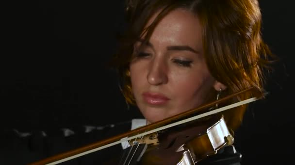 Violist meisje buigt de viool snaren. Clos omhoog. Zwarte rook achtergrond — Stockvideo