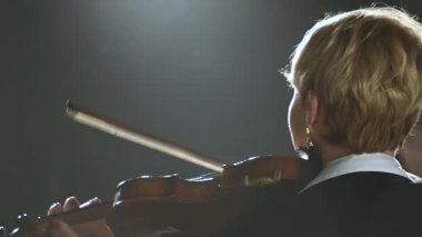 Geri duran ve keman karanlık bir odada oynayan kızlar. Siyah duman arka plan. Yakın çekim