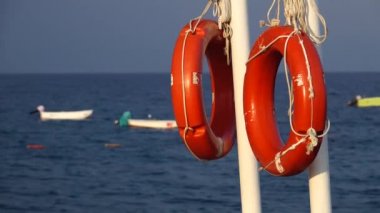 Teknenin dalgalar üzerinde sallanan deniz iskelesi Lifebuoys dayan