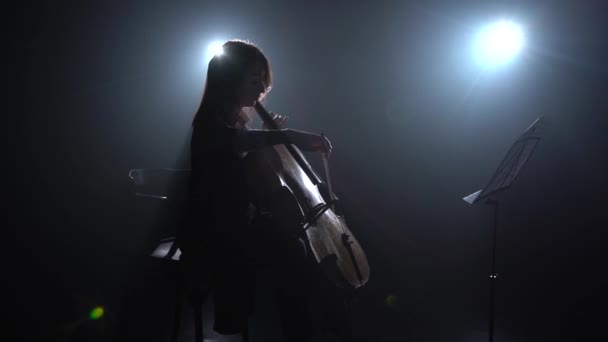 Donna Suona Violoncello Siede Una Sedia Una Stanza Buia Guarda — Video Stock