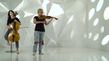 Çellist ve bir müzikal kompozisyon oynarken kemancı