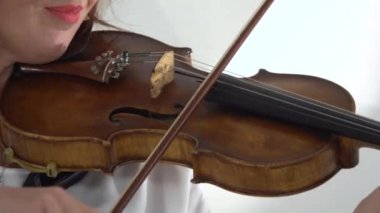 Tellere parmak keman kız oynamak. Yakın çekim. Beyaz arka plan