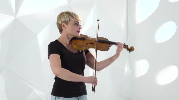 Violinista interpreta una composición musical sobre un violín en un estudio — Vídeos de Stock