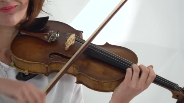 女孩在拉小提琴的琴弦上指指点点。闭上你的嘴白色背景 — 图库视频影像