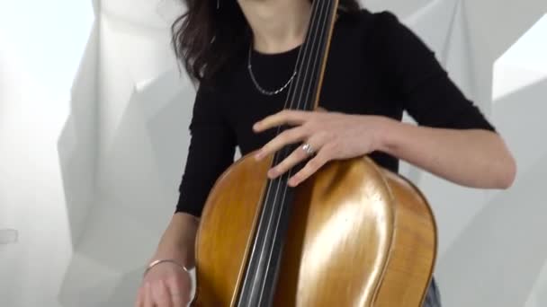 Mädchen spielt Cello zwei Mädchen spielen Geigen im weißen Studio — Stockvideo