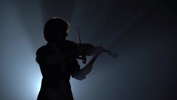 Violinist plays a lyrical work. Black smoke background. Close up. Silhouette — Stock Video